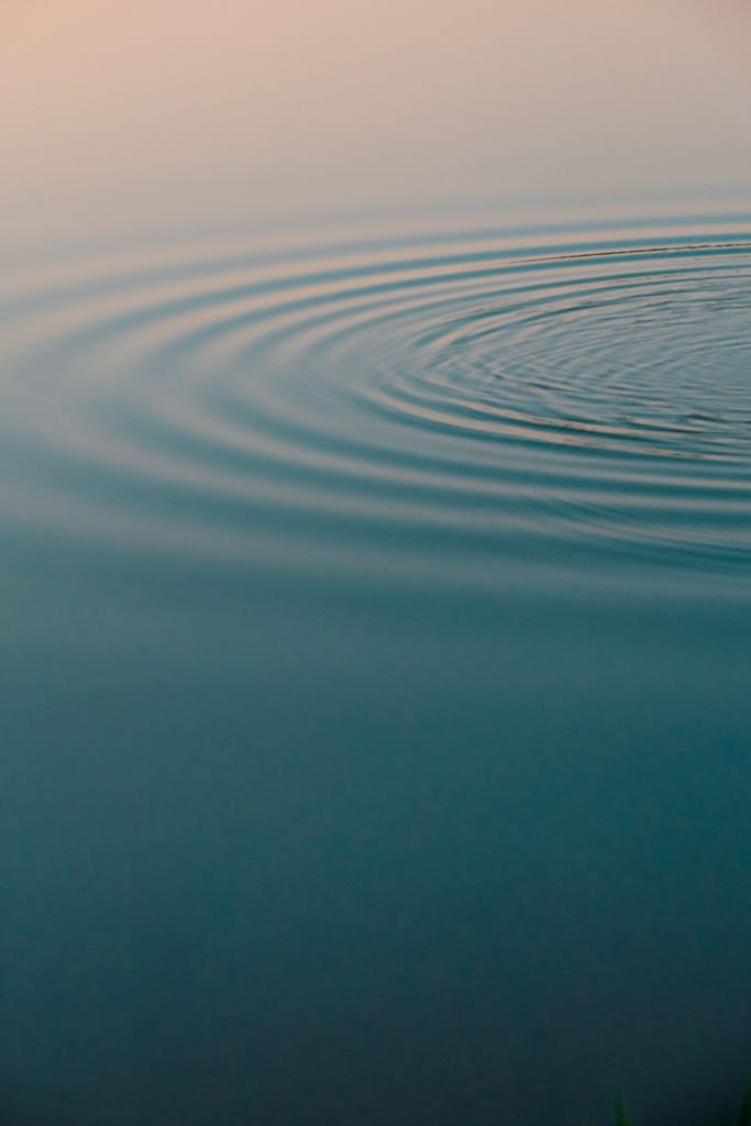 Tranquil pond with gentle ripples creating peaceful wave patterns.