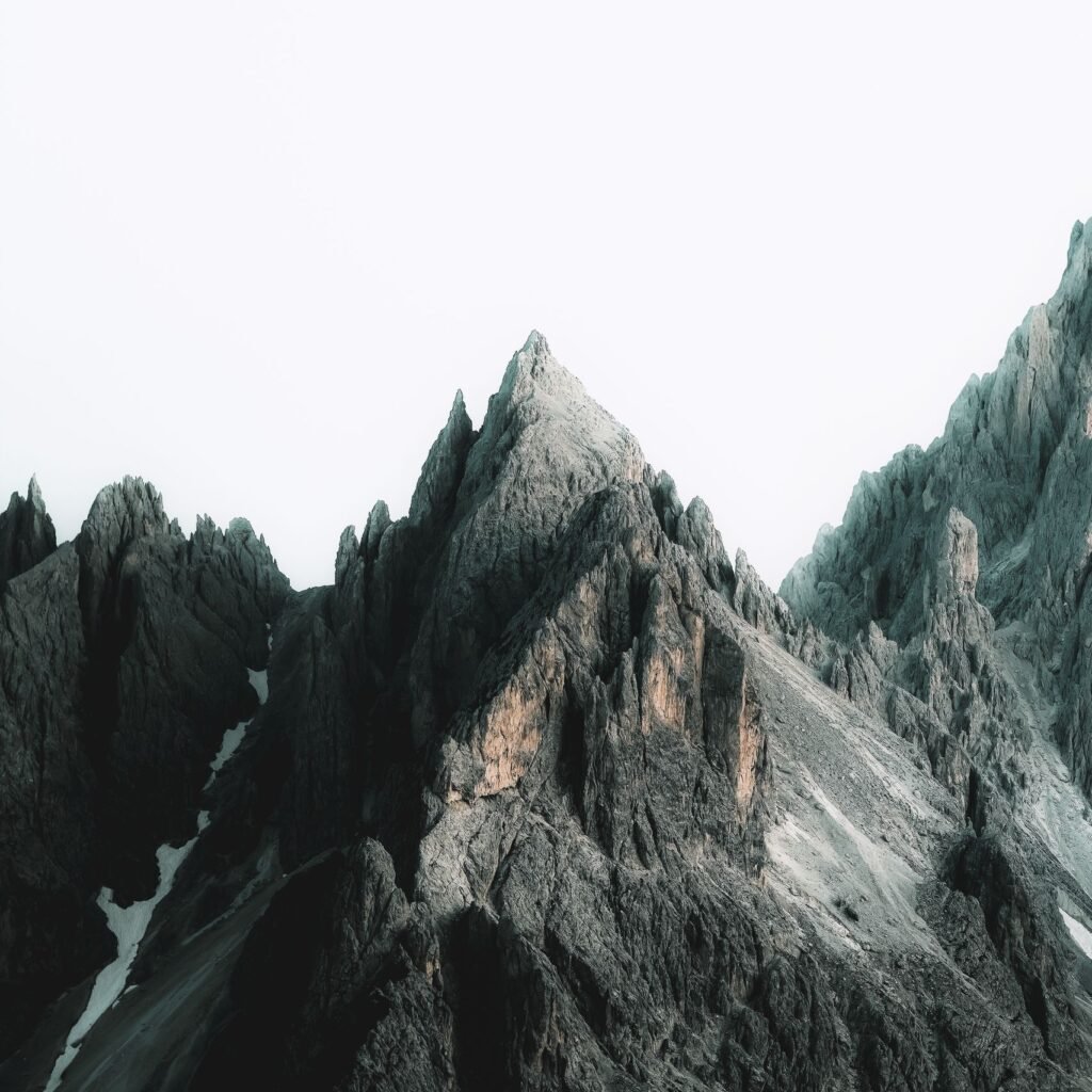 Stunning day view of the jagged Dolomites mountain peaks with snow patches.